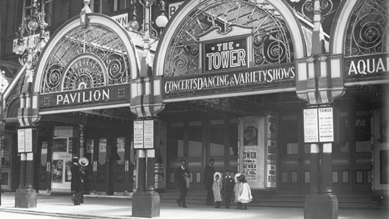 Entrance to the Blackpool Tower building with signs for 'Pavilion, Concerts, Dancing & Variety Shows.'