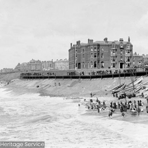 People on the beach with rough seas