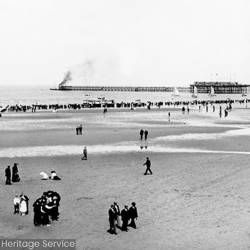 People on the beach with Blackpool North Pier in the background