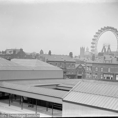 Railway platform and view over rooves to Ferris wheel