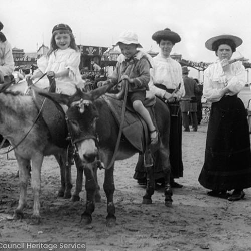 Children riding donkeys on the beach