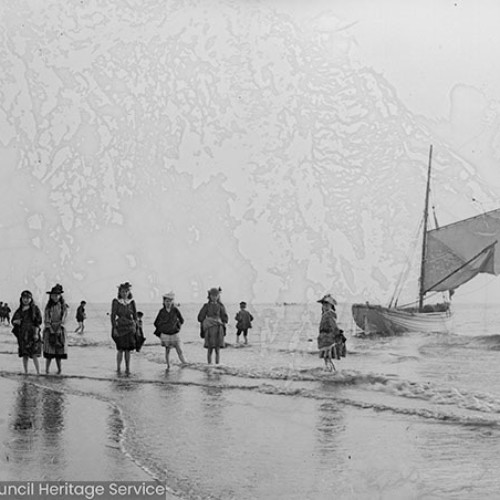 Children and sailing boat on the beach