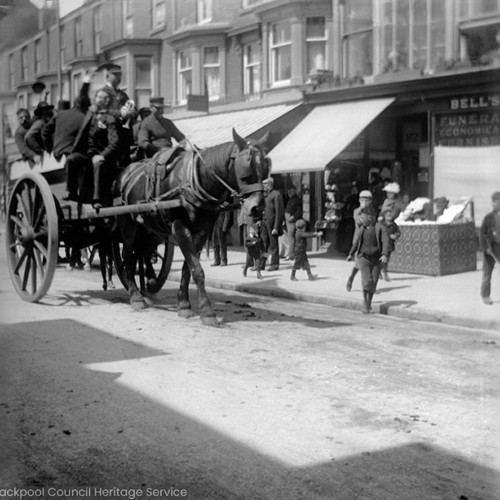 People riding horse and cart in street