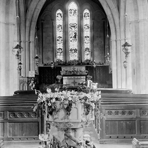 Font and stained glass window inside a church