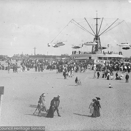 Crowds and fairground ride on beach