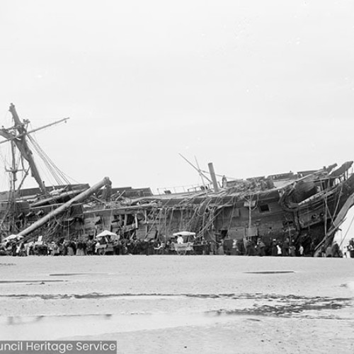 Crowds in front of shipwreck on beach