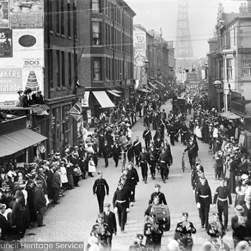 Crowds in street scene, with sign for 'Princess Hotel'. Visible adverts on wall for 'Whittaker's Marmalade' and 'Wheatleys'.