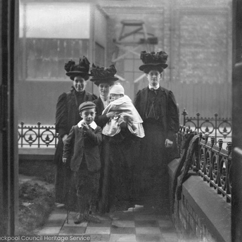 Three women and two children outside of house