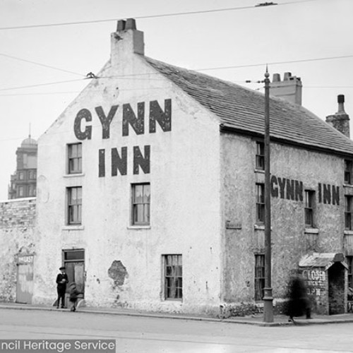 Inn building viewed from across street with 'Gynn Inn' painted on side and 'Closed' sign on door.