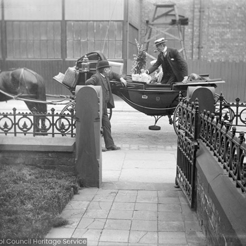 Man in carriage outside house