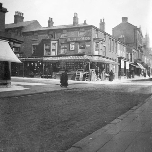 Street scene with shops including 'R. Jackson.'