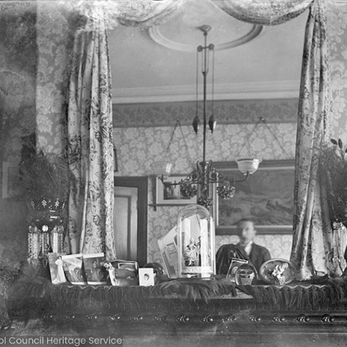 Man reflected in mirror over mantlepiece