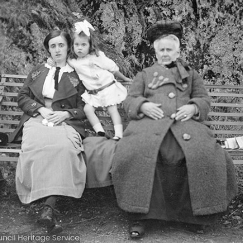 Two women on bench with young girl