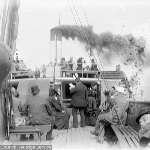 Passengers sat on deck of a paddle steamer