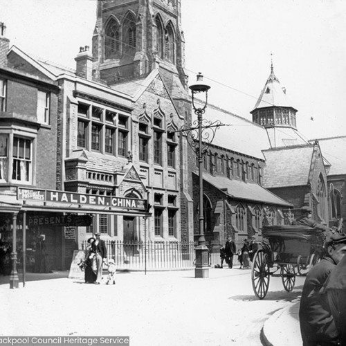 Street scene with church and school building, shop sign reads 'Halden. China'