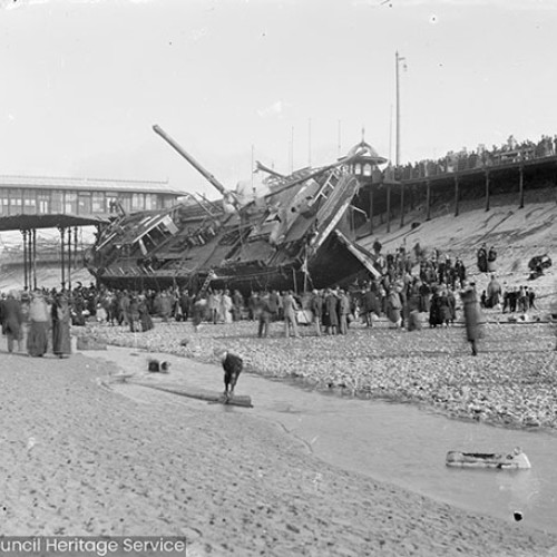 Crowds on beach in front of shipwreck