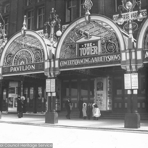 Entrance to the Blackpool Tower building with signs for 'Pavilion, Concerts, Dancing & Variety Shows.'