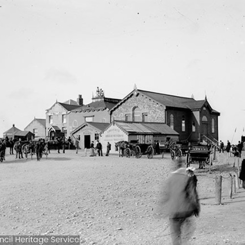 Crowds in front of wooden cabin buildings