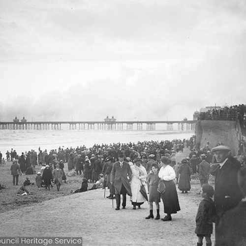 Crowds on beach watching smoke over Blackpool North Pier
