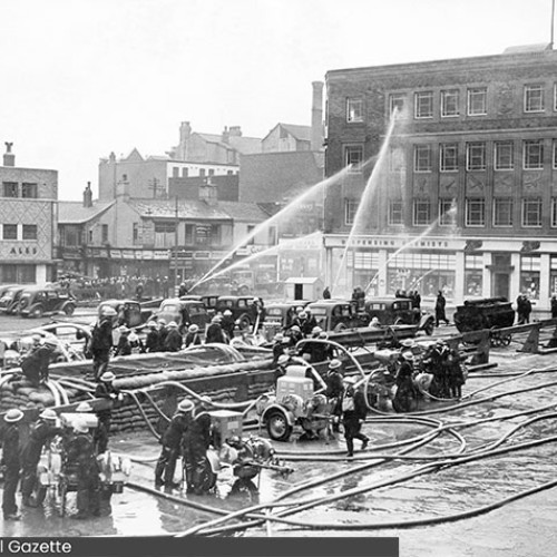Groups of people using fire hoses on a building.