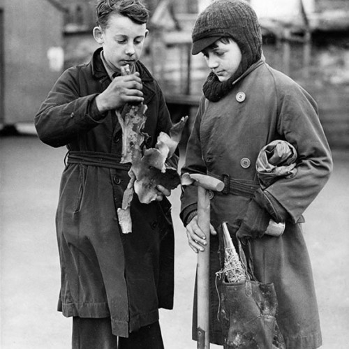 Two boys holding pieces of shrapnel from a mine.
