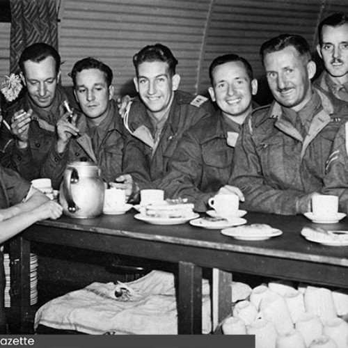 Lady serving refreshments to a group of soldiers.