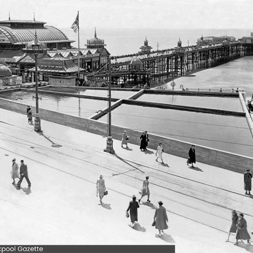 People walking around a large tank of water, which is on the right hand side of the North Pier entrance.