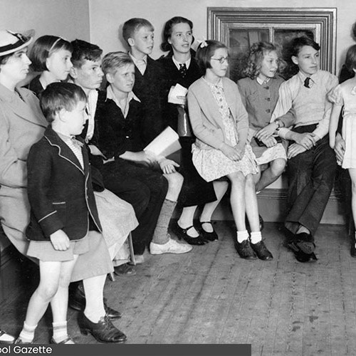 Group of women and children in the corner of a room.