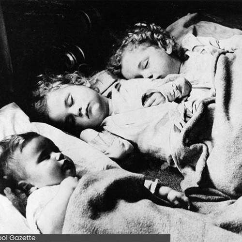 Three young children sleeping next to each other.