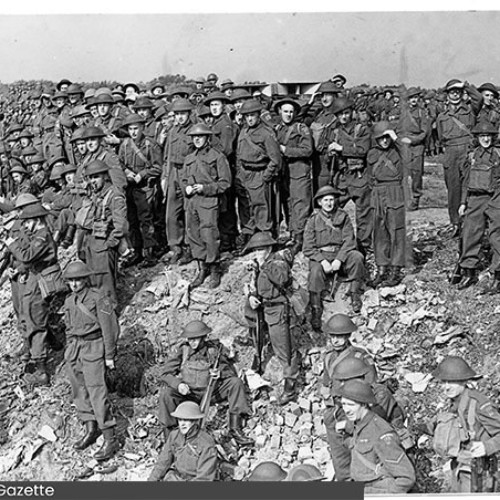 Group of Home Guard in their uniforms stood on a cliff side.