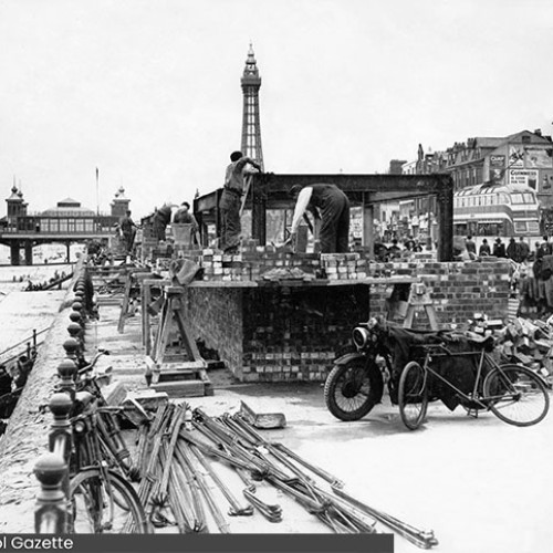 Workers constructing an air raid shelter, just behind the sea wall. Central Pier and Blackpool Tower are in the background.