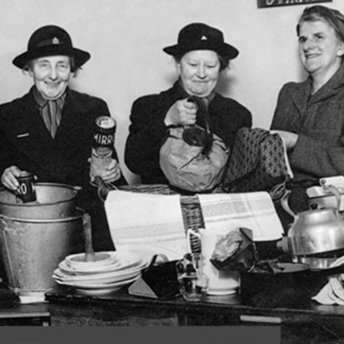 Group of five women sorting through items on a table.