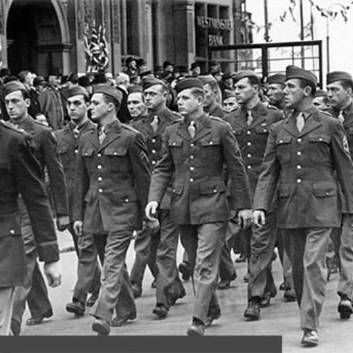 Soldiers marching in formation past the Town Hall.