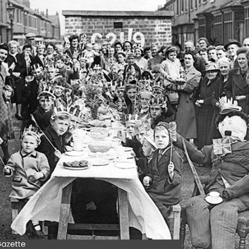 Group of people having a street party in the middle of the road.