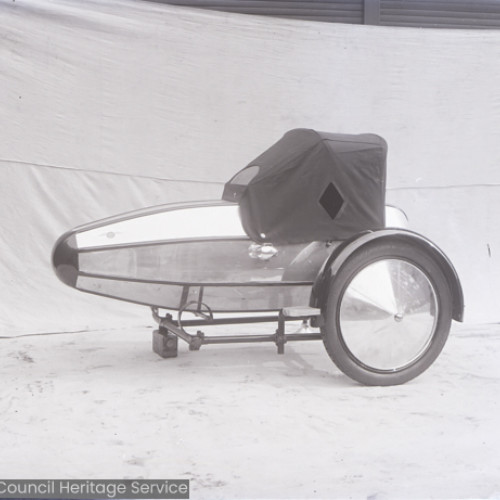 A side view of a motorcycle side car with canvas cover.
