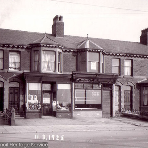 Street scene with two shops, a grocery shop and a butchers.