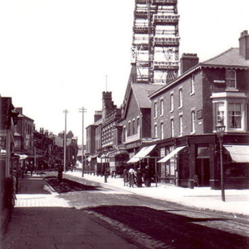 Street scene with parade of shops and the Great Wheel in the background.