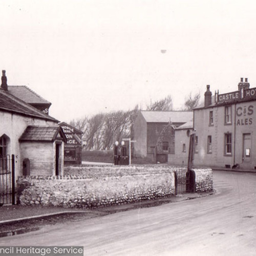 Street view of a rural cottage and a public house in the background.