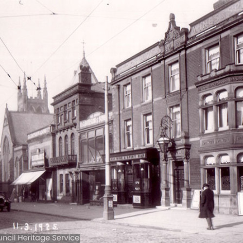 Street view of a hotel building and shops.