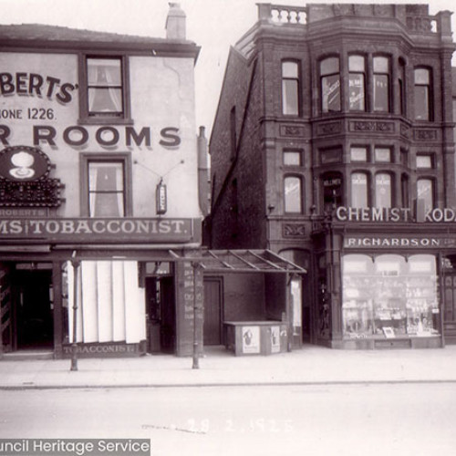 Street scene with shop and cafe frontages.