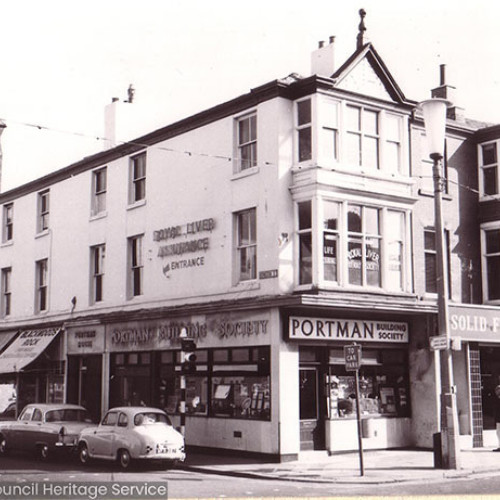 Street scene with shops and church in background.