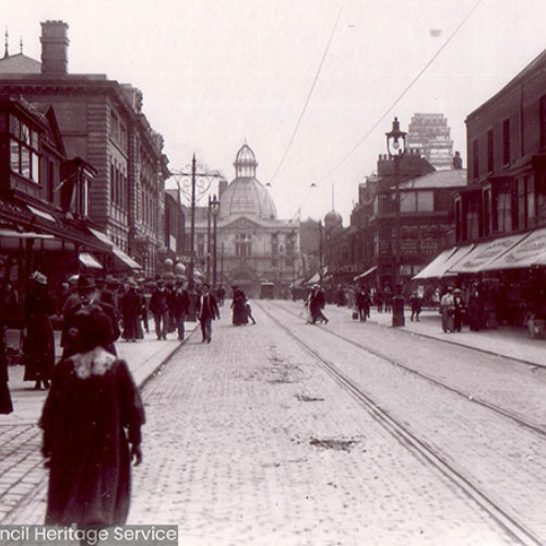 Street scene busy with pedestrians, Blackpool Winter Gardens and Great Wheel in the background.