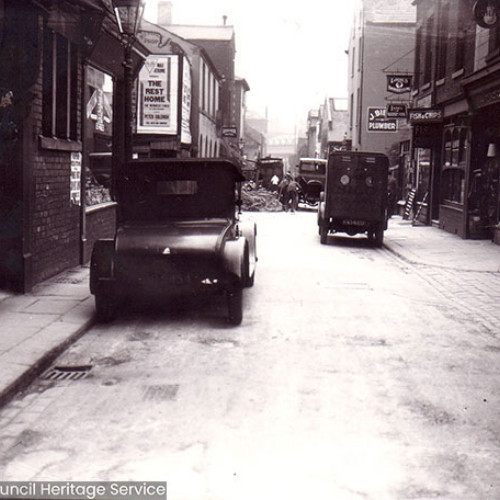 Street scene with cars vintage cars parked in street.