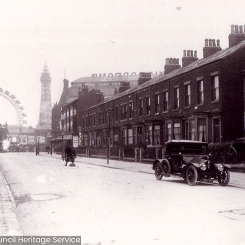 Street scene with a row of houses, in the background is Blackpool Tower and the Great Wheel.
