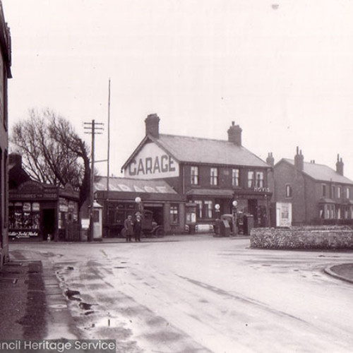 Street scene of crossroads and garage building.