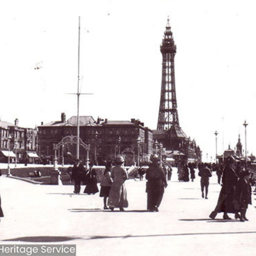 People walking on Promenade with Blackpool Tower in the background.