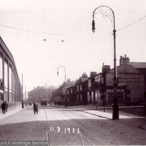 Street scene with side of Railway Station and shops.