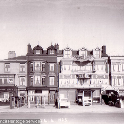 Street scene showing a row of apartment buildings and shops.