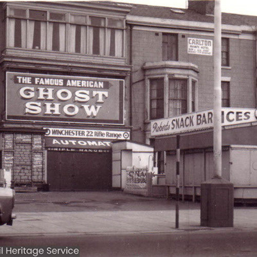 Row of buildings including The Famous American Ghost Show, the Carlton and a stall called Roberts Snack Bar, Ices.