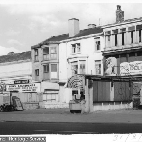 Row of buildings with signs for Palm Court and Penny Amusements, Winchester Rifle Range.